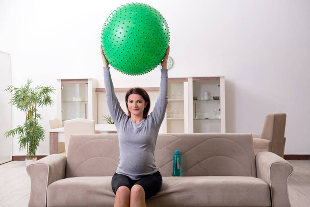Aged pregnant woman doing exercises at home  - Photo, Image