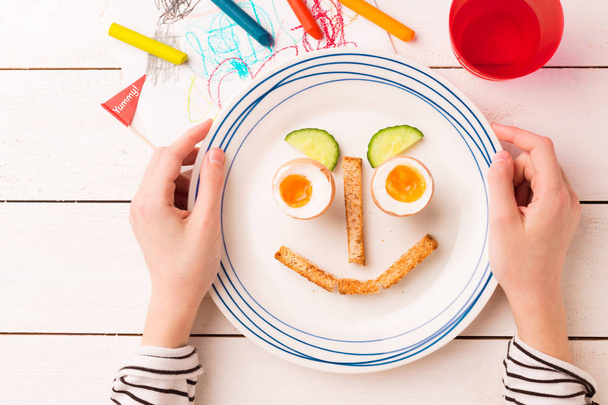 Αστείο πρωινό στα χέρια του παιδιού-αυγά και προπόσεις - Φωτογραφία, εικόνα