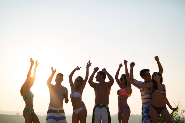 Freunde feiern bei Sonnenuntergang in den Sommerferien - Foto, Bild