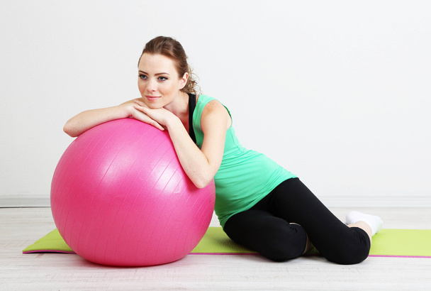 Portrait of beautiful young woman exercises with gym ball - Fotografie, Obrázek