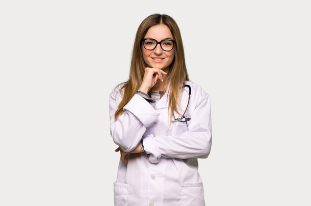 Young doctor woman with glasses and smiling on isolated grey background - Fotografie, Obrázek