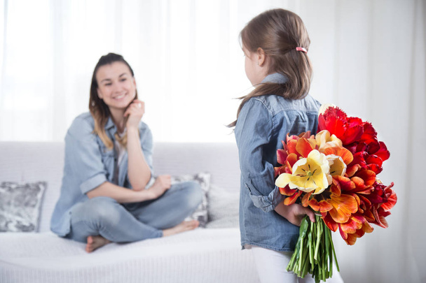 Mother's day. Little daughter with flowers congratulates her mother - Foto, Imagen