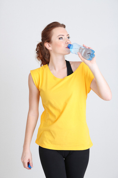 Beautiful young woman with bottle of water - Φωτογραφία, εικόνα