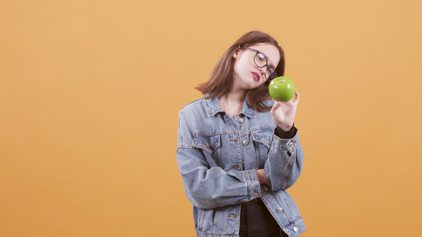 Mladá dívka drží jablko v ruce a podporuje zdravé stravování - Záběry, video