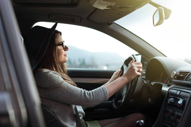 Young hipster woman with eyeglasses and hat driving the car.  - Foto, Imagem