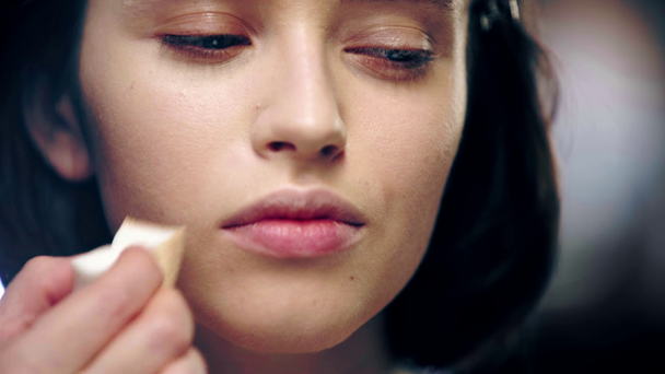 vista de perto do artista de maquiagem aplicando fundação rosto no rosto modelo com esponja cosmética
 - Filmagem, Vídeo