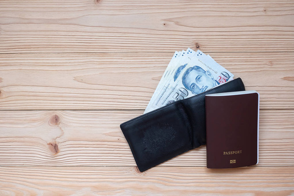 Money banknote in black wallet with Passport on wooden table, To - Фото, изображение
