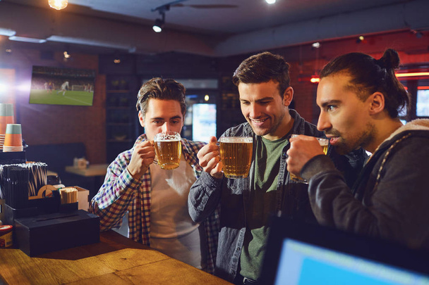 Friends drink beer from glasses in the bar. - Fotografie, Obrázek