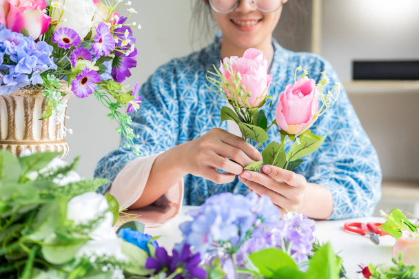 junge Geschäftsinhaberin Floristin, die Kunstwerke herstellt oder arrangiert - Foto, Bild