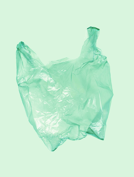 Light green plastic bag on green background. - Foto, afbeelding
