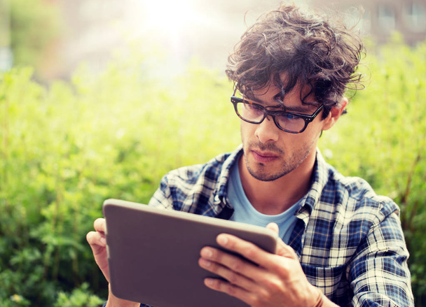 man in glasses with tablet pc computer outdoors - Foto, Imagen