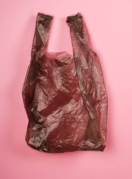 Bright gray plastic bag on red background. - 写真・画像