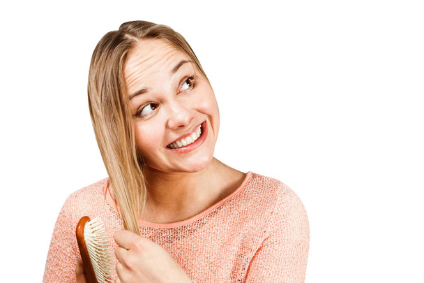 Retrato de uma bela mulher jovem sorridente pentear o cabelo, isolado no fundo branco
 - Foto, Imagem
