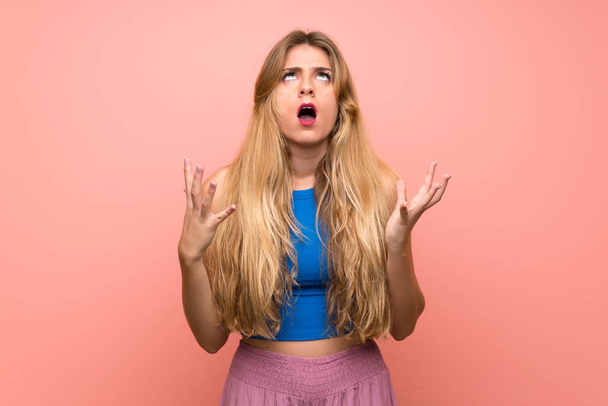 Young blonde woman over isolated pink background frustrated by a bad situation - Foto, afbeelding