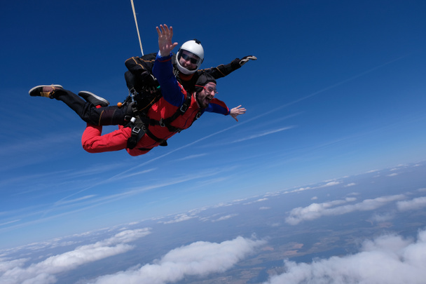 Tandem paraşütle atlama. İki mutlu adam gökyüzüne düşüyor.. - Fotoğraf, Görsel