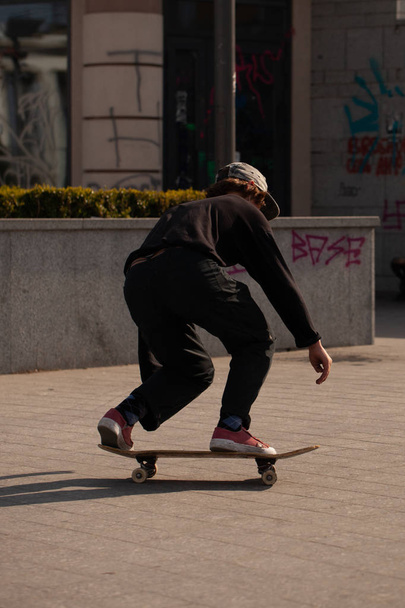 Mladí kluci ve stylovém oblečení jezdit na skateboardu v parku. - Fotografie, Obrázek