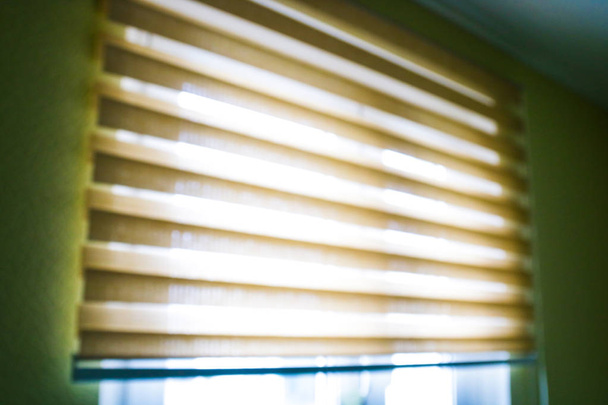 Крупный план коричневого цвета Роликовые жалюзи шторы. солнечный свет через окна и роллер вслепую в городе. Мягкое изображение
. - Фото, изображение