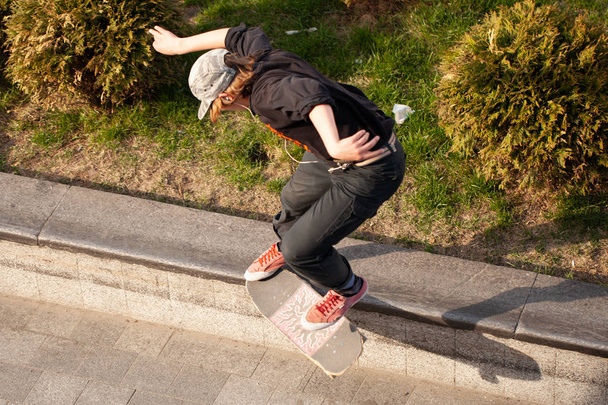 Young guys in stylish clothes ride a skateboard in the park. - Foto, immagini