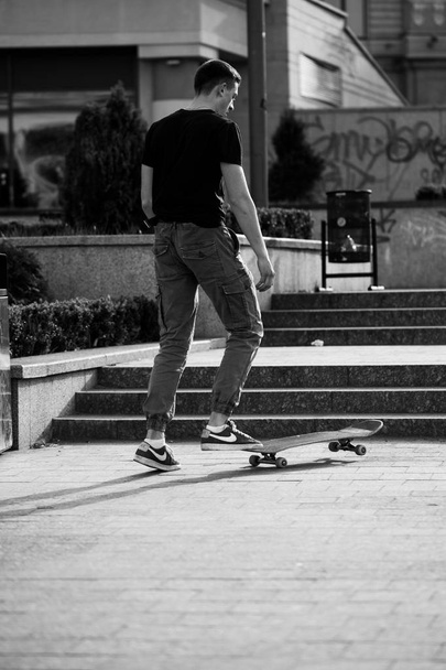 Junge Kerle in stylischen Klamotten fahren im Park Skateboard. - Foto, Bild