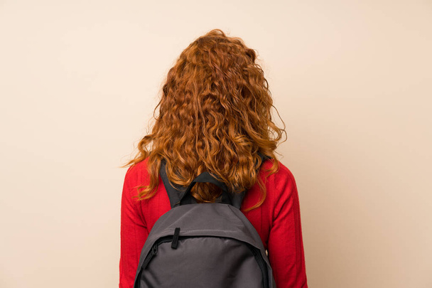Redhead woman with turtleneck sweater with backpack - 写真・画像