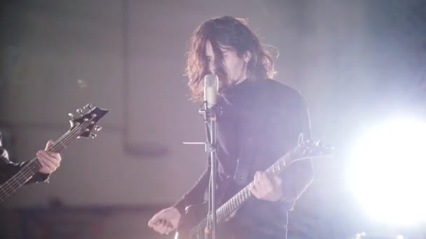 A rock group having a repetition. A soloist with long hair singing and playing guitar - Footage, Video