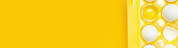 Oeufs de poulet blanc dans un emballage jaune sur fond jaune vue du dessus plat déposer l'espace de copie. Œufs en boîte, aliments naturels sains et concept d'agriculture biologique. Alimentation créative fond minimaliste, Pâques
 - Photo, image