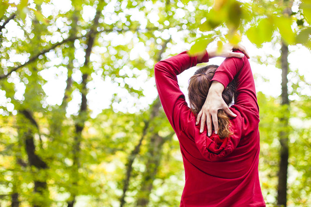 Young woman stretching arm and shoulder outdoors - Photo, image
