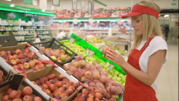 Beautiful supermarket saleswoman in red uniform giving thumb up - Filmati, video