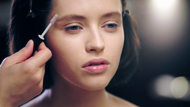 vista recortada del artista de maquillaje cepillado modelo ceja
 - Metraje, vídeo
