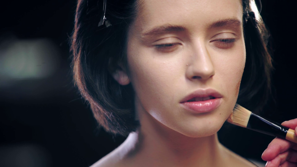 kozmetik fırça ile model yüzünde şekillendirme yapan makyaj sanatçısı kırpılmış görünümü - Video, Çekim
