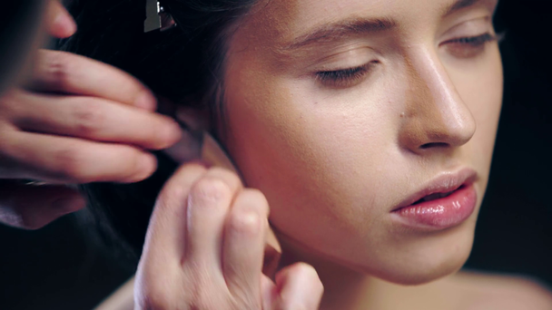 oříznutý pohled na líčidla stínování na modelový obličej pomocí Kosmetické houbičky izolované na černém - Záběry, video