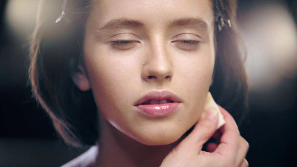recortado vista de maquillaje artista sombreado contorno en la cara modelo con esponja cosmética
 - Metraje, vídeo