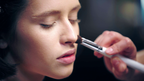 kozmetik fırça ile model yüzünde makyaj sanatçısı gölgeleme yüz temel kırpılmış görünümü - Video, Çekim