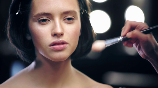 recortado vista de artista de maquillaje aplicando rouge en la cara del modelo
 - Imágenes, Vídeo