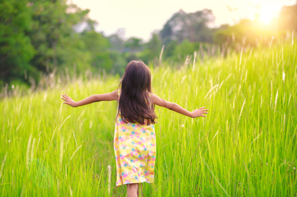 Happy little girl running on meadow - Photo, Image