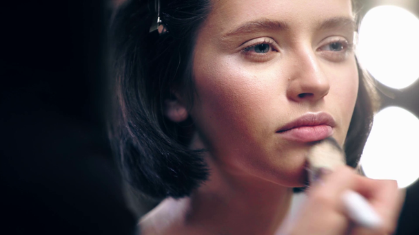 cropped view of makeup artist powdering model face with cosmetic brush - Filmagem, Vídeo