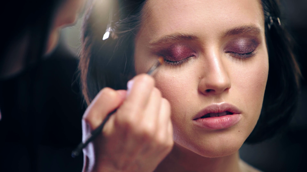 oříznutý pohled na makeup umělec stínování hnědé stíny s kosmetickým kartáčkem - Záběry, video