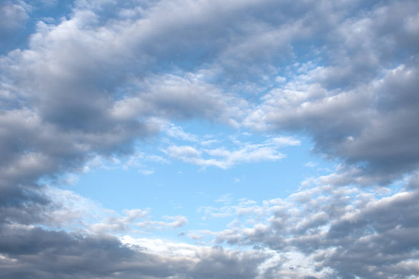 Вид на небо блакитний у вигляді серця через повітряні хмари сірого
 - Фото, зображення