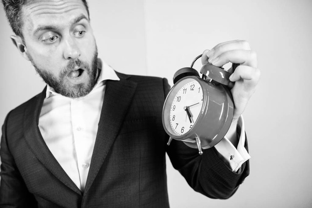 Stress concept. Mature man with wondering. Businessman has lack of time. Time management skills. How much time left till deadline. Time to work. Man bearded surprised businessman hold clock - 写真・画像
