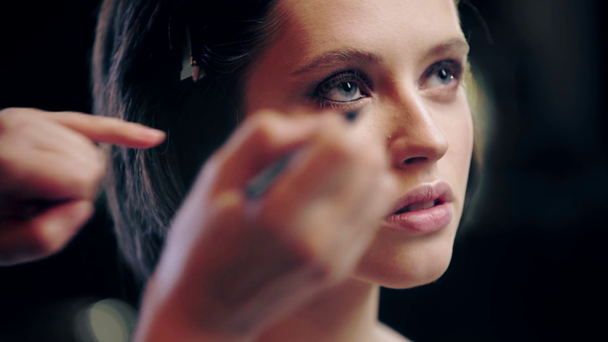 przycięte widok makijaż artysty stosowania czarnego eyeliner na modelu dolnej powieki - Materiał filmowy, wideo