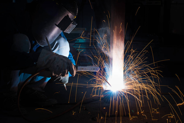 Welding skills training of welder with protective mask and welding steel metal part. - Foto, Bild