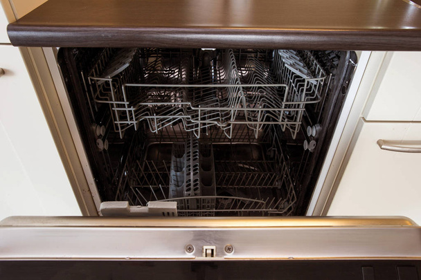 сучасна напіввідкрита порожня посудомийна машина на сучасній кухні
 - Фото, зображення