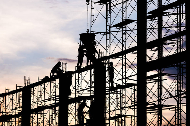 Silhouette of worker. Construction Building casting concrete work on scaffolding. - Photo, Image