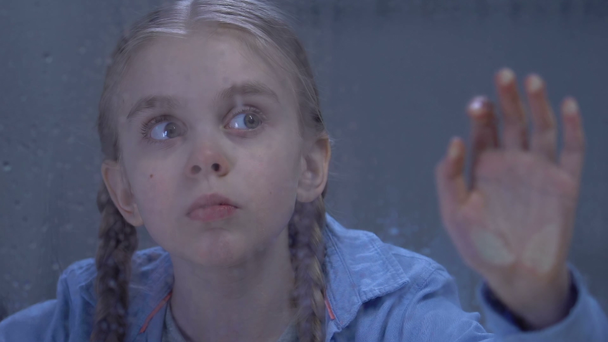 Adorável solitário menina pré-adolescente olhando chuva através da janela assustado por trovoada
 - Filmagem, Vídeo