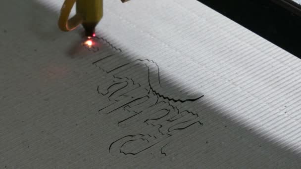 Jakiś napis jest wykonany z urządzenia laserowego na falistej białej płycie w fabryce - Materiał filmowy, wideo