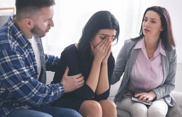 Psychologist comforting sad female patient in office - 写真・画像