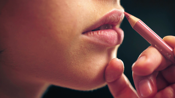 visão parcial de maquiador aplicando forro labial em lábios modelo isolado em preto
 - Filmagem, Vídeo