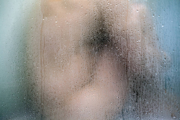 ヌードの男がシャワーバスに座っている。ヒアぼやけたシルエット - 写真・画像