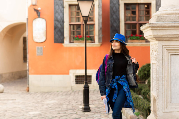 A young tourist walking in the old courtyard, near the red wall in Lviv. Ukraine - Fotografie, Obrázek