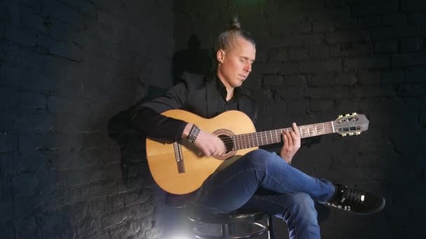 guitar player playing flamenco music on a black brick wall background - Imágenes, Vídeo